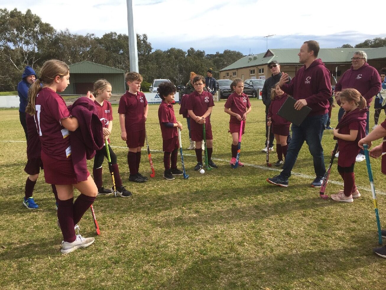 group of hockey players listening to coach